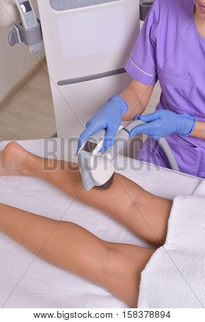 Young beautiful woman gets professional body shape treatment in a beauty clinic