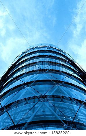 Modern office building with blue glass facade and the blue sky