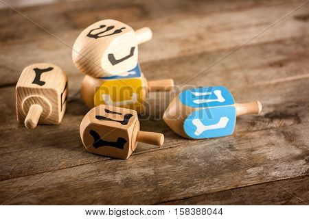 Composition of dreidels for Hanukkah on wooden table