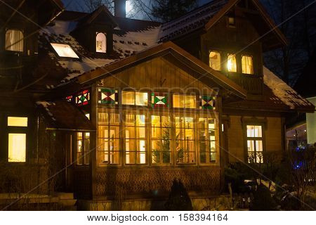POLAND ZAKOPANE - JANUARY 03 2015: Traditional wooden cottage house on the street in Zakopane. Town known as the winter capital of Poland. It is a popular destination for mountaineering skiing and qualified tourism.