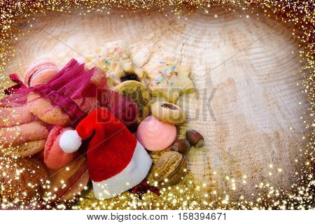 Various Christmas cookies in red sack solated on wood background. Christmas decoration with hat.