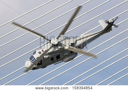 ROTTERDAM NETHERLANDS - SEP 3 2016: Royal Netherlands Navy NH90 helicopter flying past the Erasmus bridge during the World Harbor Days in Rotterdam.