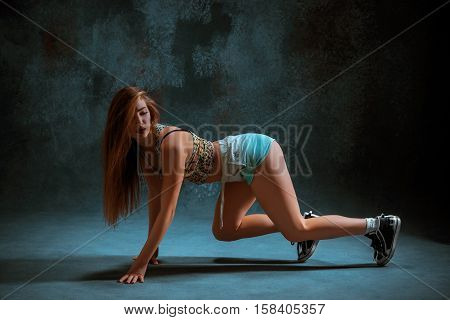Attractive girl dancing twerk iat the blue studio background