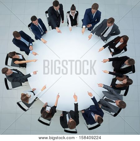 Top view of smilimg business team, sitting at a round table on w