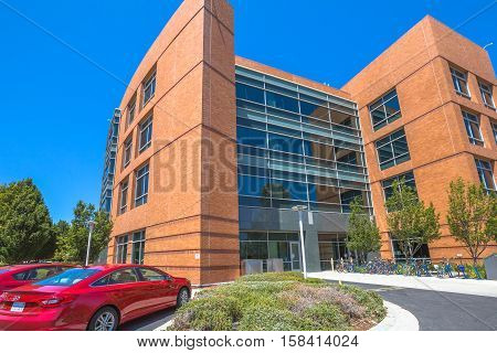 Mountain View, California, United States - August 15, 2016: Google Building 1950 with red car and colored bikes parked. Google is a multinational corporation.