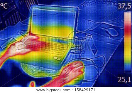 Infrared thermography image showing the heat emission when woman used notebook