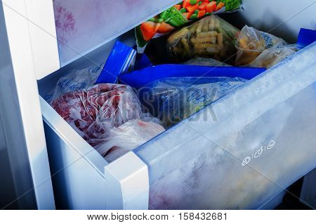 Various frozen vegetables in plastic bags in freezer