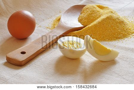Heap Of Corn Meal, Wooden Spoon And Eggs