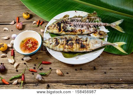 grilled fish with spicy sauce on wooden background