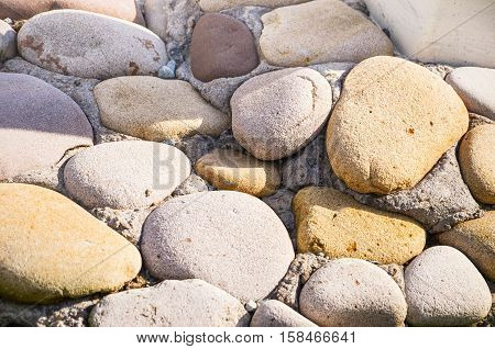 background of smooth sea stones close-up yellow in gray tones