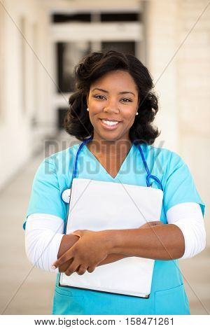 African American female doctor at work holding a notebook.