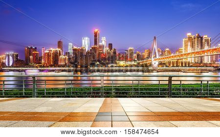 cityscape and skyline of downtown near water of chongqing at night
