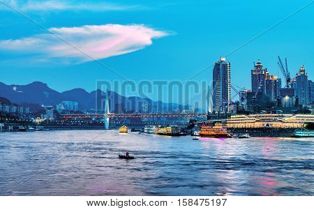 cityscape and skyline of downtown near water of chongqing at night