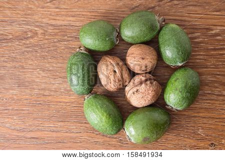 Feijoa Fruit And Walnuts On Wooden Background