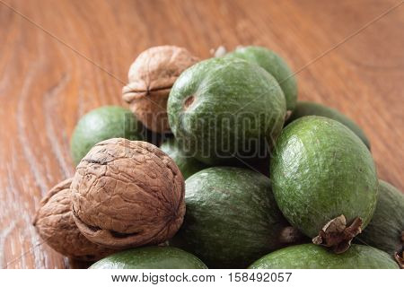 Feijoa Fruit And Walnuts On Wooden Background