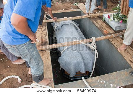 a coffin will be put into the ground to be buried in funeral ceremony
