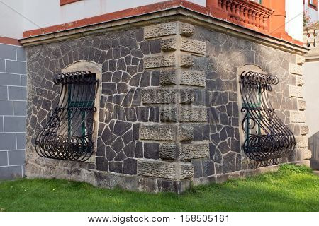 Window with iron grating and old wall of a castle