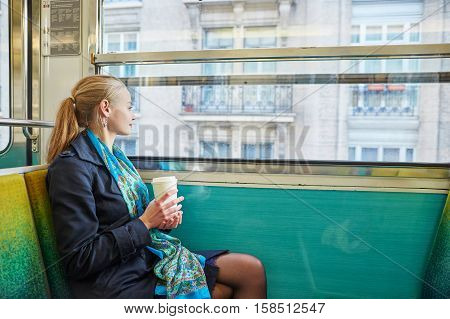 Woman Travelling In A Train Of Parisian Underground And Drinking Coffee