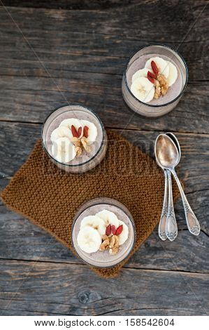 View of chocolate pana cota with banana and goji berry on a wooden table