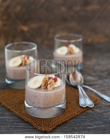 View of chocolate pana cota with banana and goji berry on a wooden table