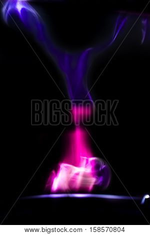 A blue and purple smoke in the darkness