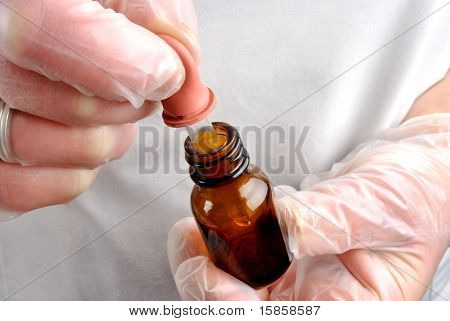 Personale di assistenza sanitaria con guanti monouso e pipetta