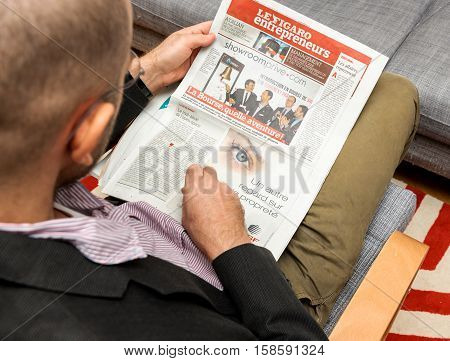 PARIS FRANCE - NOV 12 2016: Man reading Le Figaro French Entrepreneur newspaper - cover with showroomprive.com first day on stock market