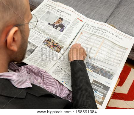 PARIS FRANCE - NOV 12 2016: Man reading Le Figaro French newspaper - article about the best company to work for in France