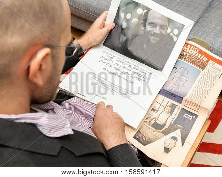 PARIS FRANCE - NOV 12 2016: Man reading Le Figaro French newspaper reading advertising about Android Software integration by startups