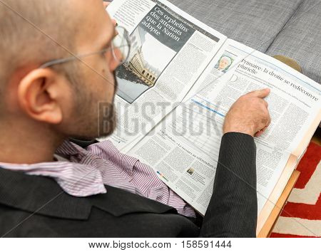 PARIS FRANCE - NOV 12 2016: Man reading Le Figaro French newspaper about the The Republicans (France) presidential primary