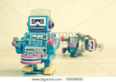 Old robot toy on wood table, vintage color style, vintage tone background.