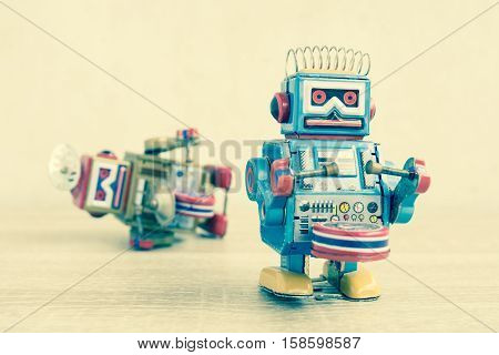 Old robot toy on wood table, vintage color style, vintage tone background.