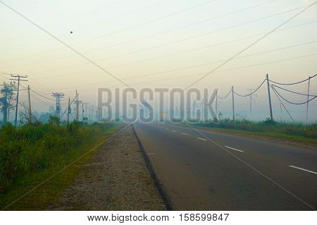 Foggy morning in Kuala Penyu,Sabah,Borneo.Road hrough the jungle and villages.