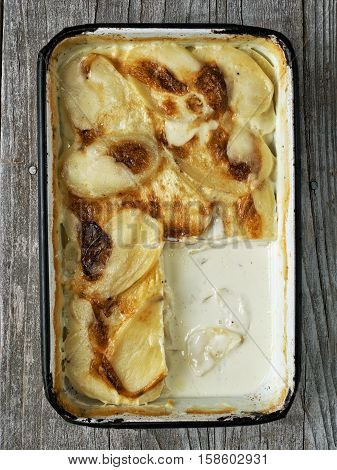close up of rustic golden scalloped potato gratin dauphinois