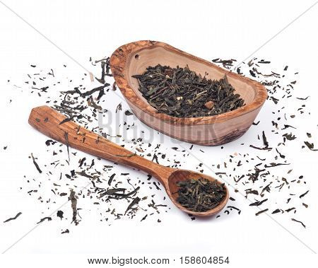 Spring organic rejuvenation green tea with refreshing orange peel and subtle peach pieces in olive wood bowl and wooden spoon isolated on white background