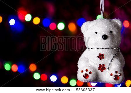 hanging Christmas teddy bear on a new year garland background