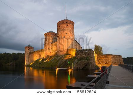 Olavinlinn's fortress in August twilight in night illumination. Savonlinna, Finland