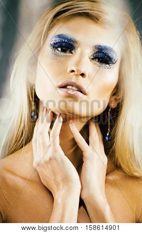 beauty young snow queen lady in fairy flashes with hair crown on her head close up in cold blue light