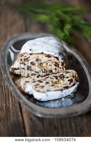 Christmas stollen. Traditional German, European festive dessert. Ingredients cranberries, pine nuts for Christmas Stollen. Stollen cake cut into pieces. Christmas food card.