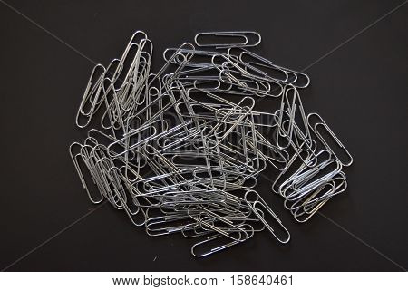 bunch of metallic paperclips assorted in grey background