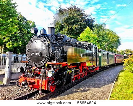 Steam locomotive on the railway. Sunny day.