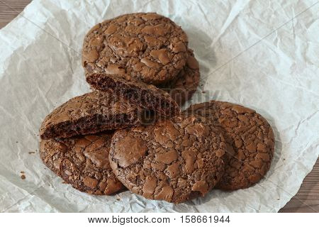 Fudge brownie cookies heap on parchment and dark background