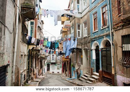 ISTANBUL, TURKEY - JAN 12, 2012: Clean clothes drying on a rope between old houses of narrow street of area Tarlabasi on January 12, 2012. Istanbul is located on area of 5343 sq.km with popul. 13483052