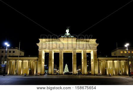 Night view on the famous illuminated Brandenburg Gate in Berlin Germany and Christmas tree.