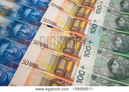 PLN EURO and CHF banknotes laying in a rows