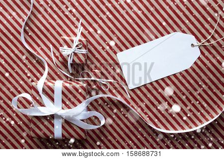 Two Gifts Or Presents With White Ribbon. Red And Brown Striped Wrapping Paper. Christmas Or Greeting Card With Snowflakes. Label With Copy Space For Advertisement Or Free Text Here