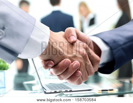 closeup of handshake of businessmen on background of the workpla