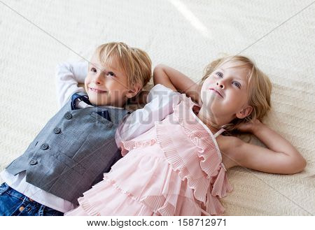 Brother and sister are lying on the floor. Studio shot