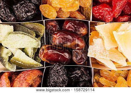 Assortment of dried fruits closeup background in square cells. Decorative pattern of dry exotic fruit. Top view.