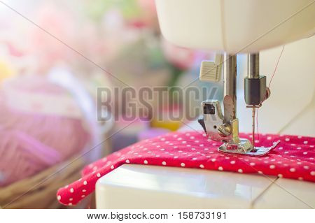 Close up of sewing machine working with red fabric